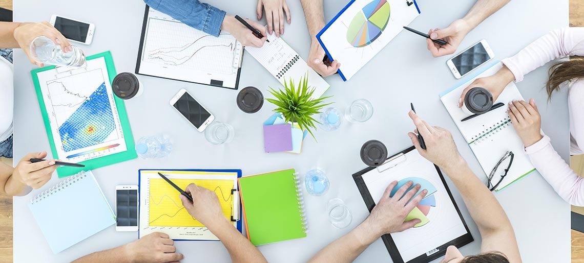 The six people work at the table. view from above