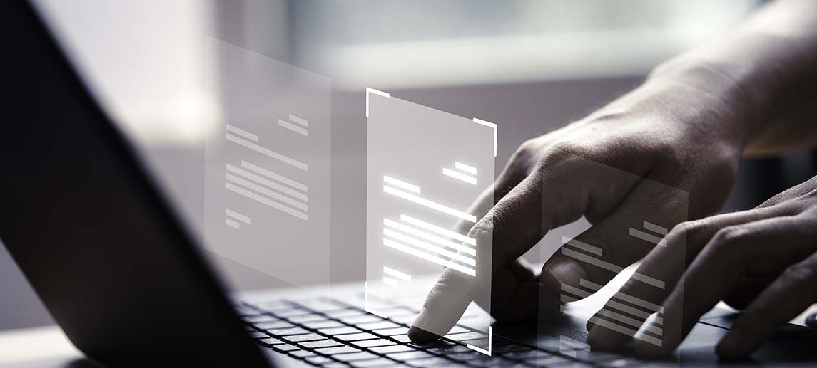Hand using laptop computer with virtual screen and document for online approve paperless quality assurance and ERP management concept.